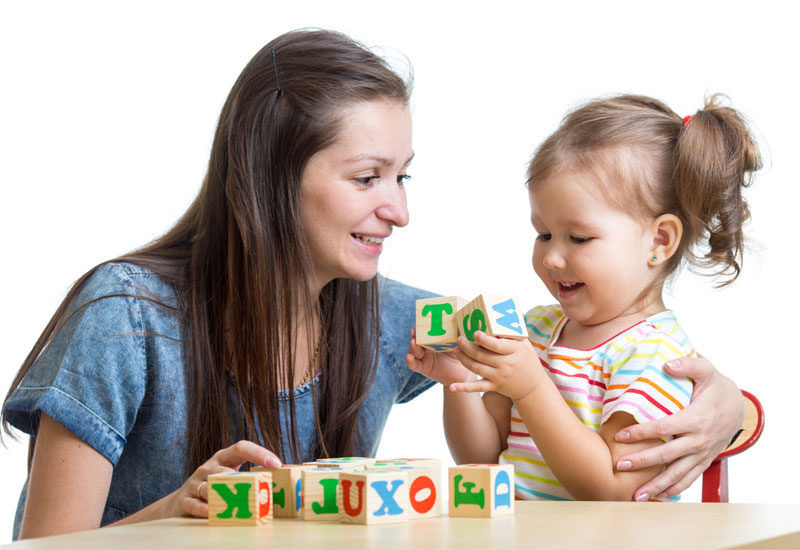 woman with child playing alphabet blocks