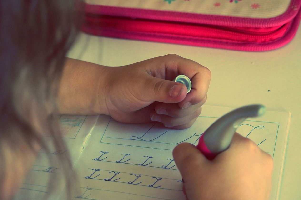 closeup of child learning and practicing cursive handwriting