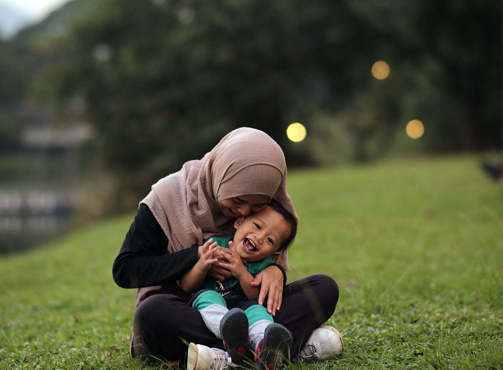 happy and loving mother holding daughter in a park