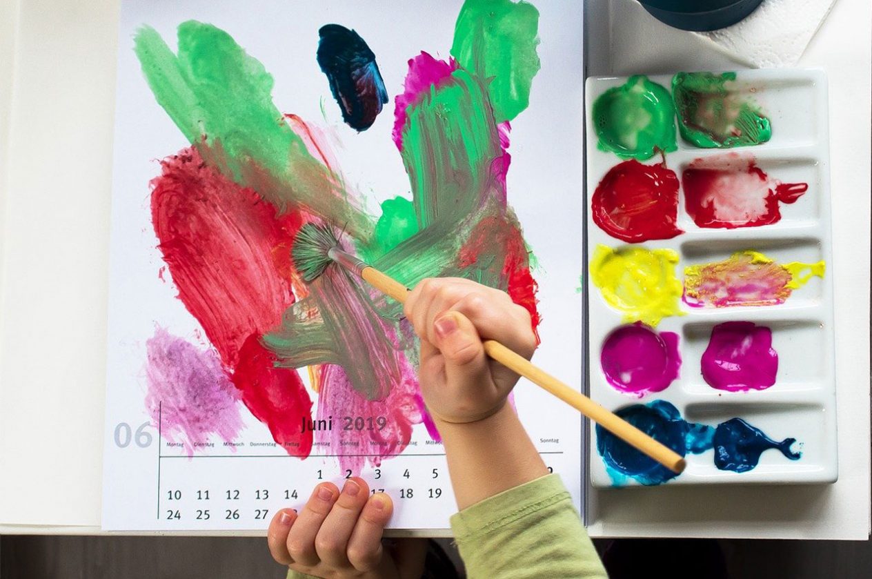 closeup of kid painting on calendar from above