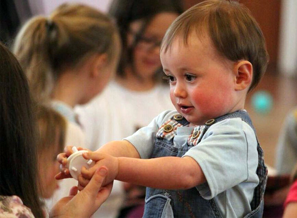 Cute toddler boy holding toy