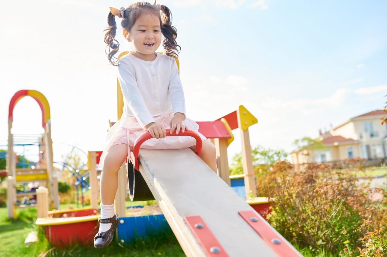 child playing on see saw in playground